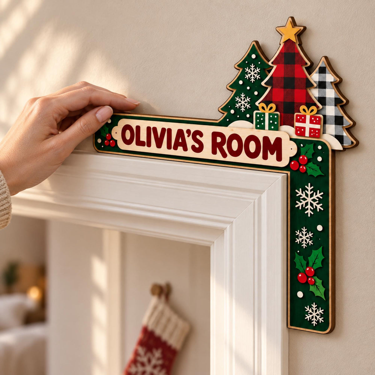 May include: A wooden L-shaped door corner sign featuring the text OLIVIA'S ROOM in dark red letters. The design includes three Christmas trees, two small gift boxes, white snowflakes, and red holly berries on a dark green background.