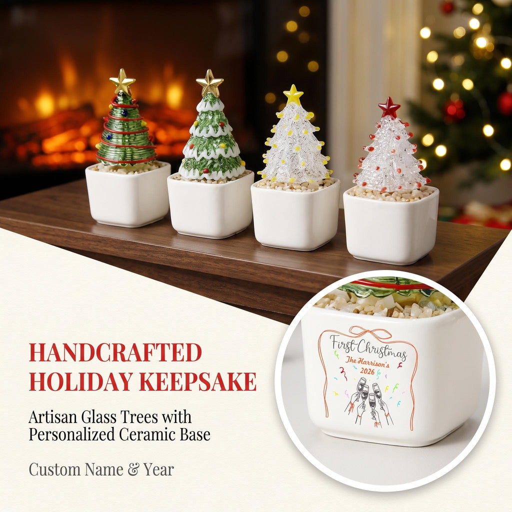 May include: Four miniature glass Christmas trees in square white ceramic pots. Each tree features a star topper. One pot shows text reading First Christmas, The Harrison's 2026, and an illustration of hands holding champagne glasses with confetti.