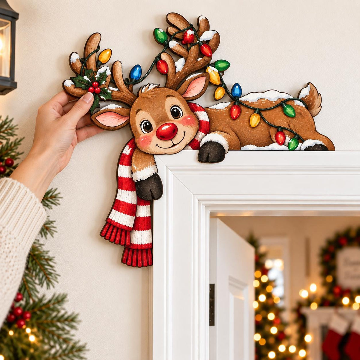 May include: A decorative wooden reindeer door topper featuring a brown reindeer with a red nose, wearing a red and white striped scarf, and tangled in a string of colorful Christmas lights with green holly leaves and berries on its antlers.