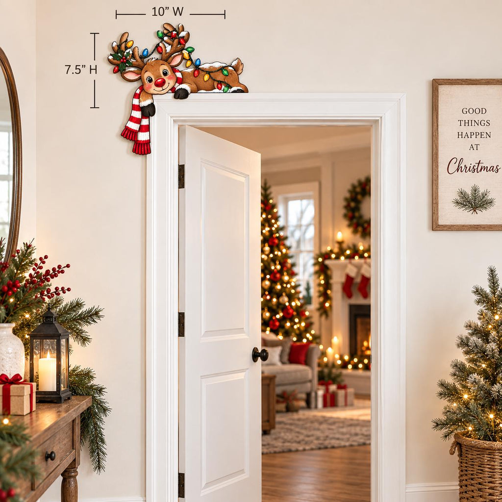 May include: A decorative wooden reindeer door corner sign featuring a brown reindeer wearing a red and white striped scarf and tangled in colorful Christmas lights. The sign measures 10 inches wide by 7.5 inches high and is designed to sit on a door frame.