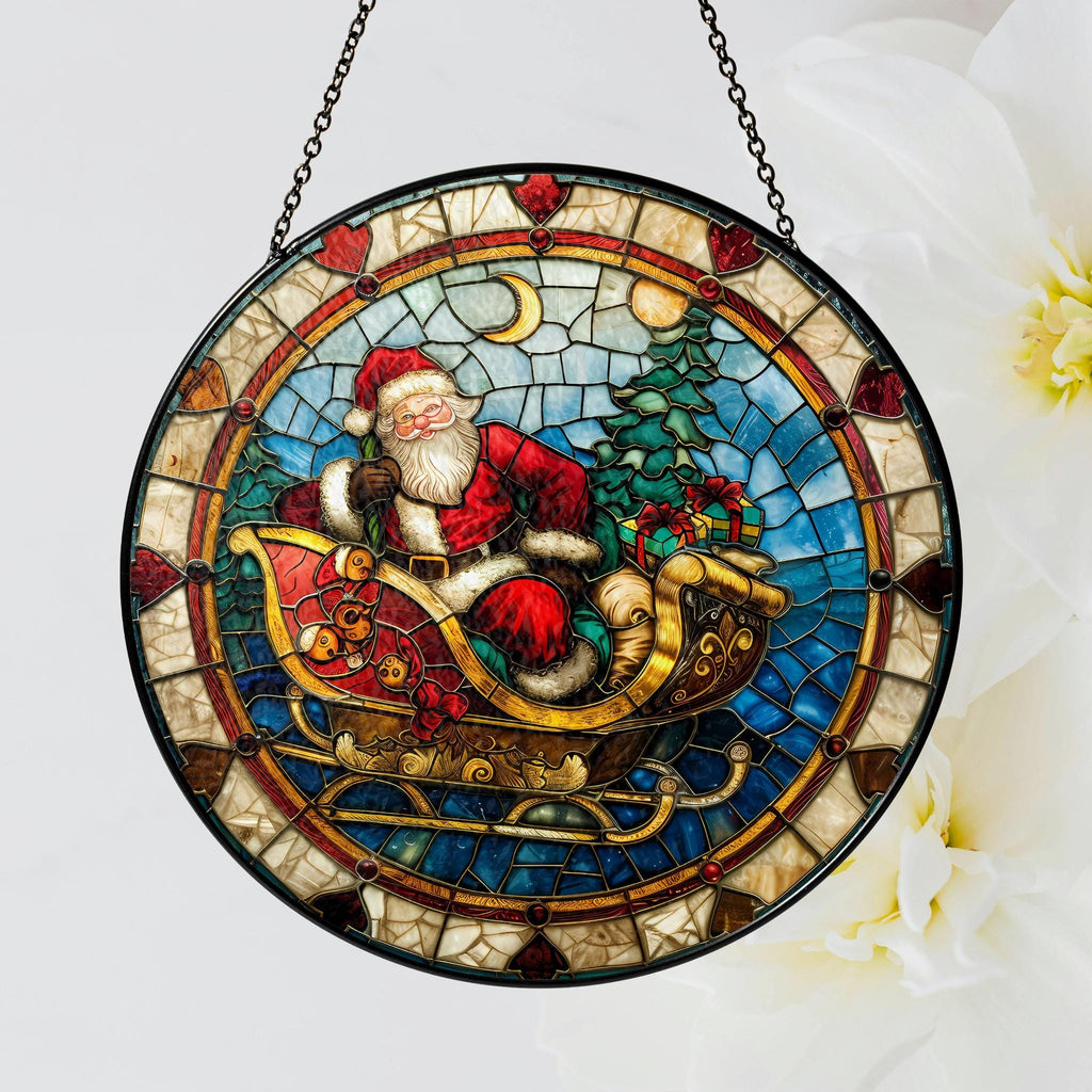 May include: A stained glass window hanging ornament featuring Santa Claus riding in a sleigh with presents. The sleigh is decorated with gold accents and the background is a mosaic of blue, green, and red.