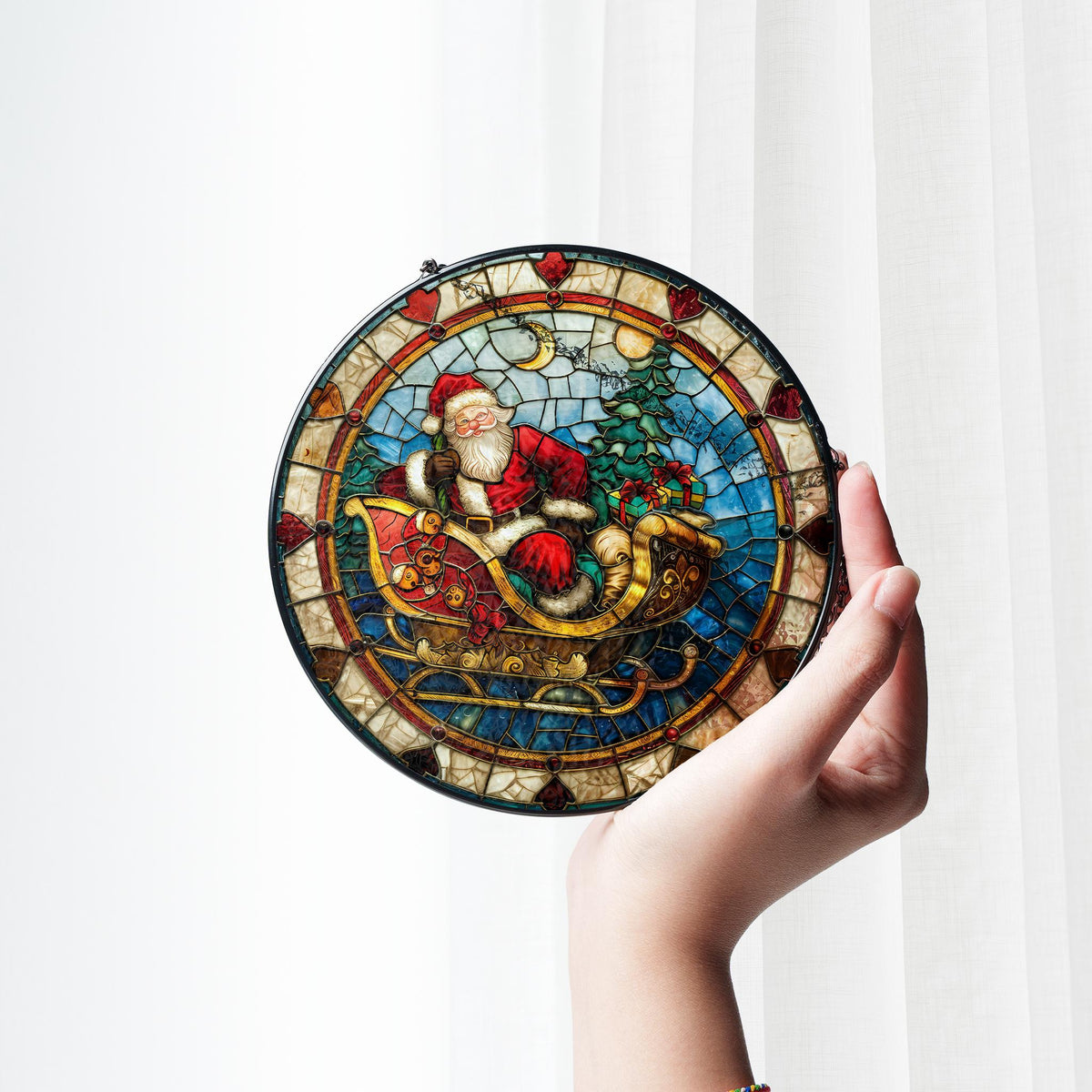 May include: A round stained glass ornament featuring a colorful depiction of Santa Claus riding in a sleigh pulled by reindeer. The ornament has a black frame and a mosaic-like design.
