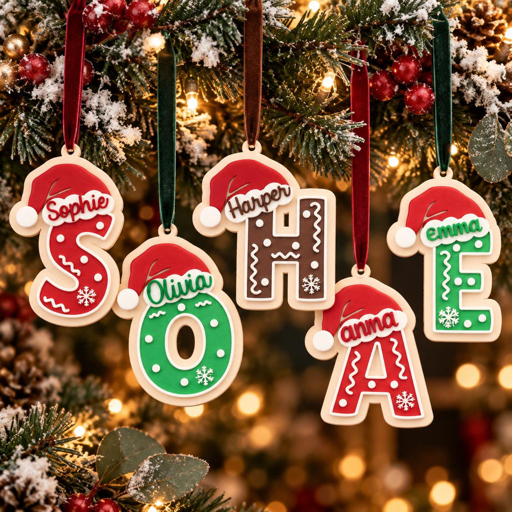 May include: Five hanging Christmas ornaments shaped as letters S, O, H, A, and E. Each letter features a red Santa hat, white snowflake accents, and a personalized name. The letters are colored in red, green, or brown and hang from velvet ribbons.
