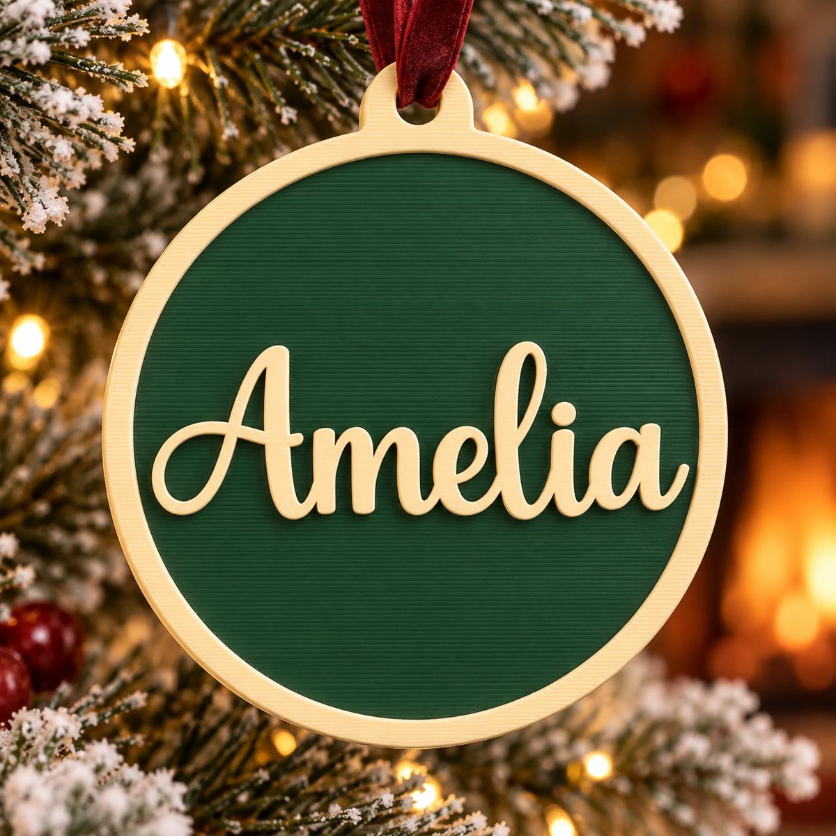 May include: A circular Christmas ornament featuring a dark green center with a textured horizontal line pattern. The name Amelia is written in a gold-colored script font across the middle. The ornament has a gold-colored frame and a red ribbon.