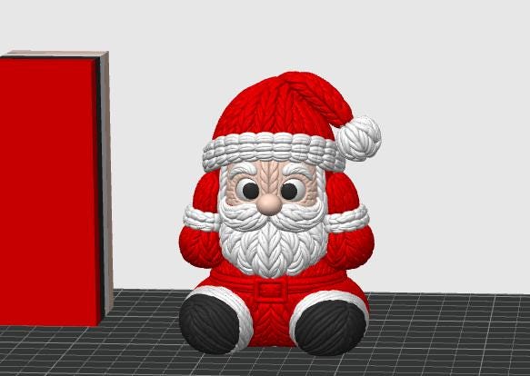 May include: A 3D rendered Santa Claus figurine featuring a textured knit pattern throughout. The figure wears a red hat with a white pom-pom and trim, a red coat with a white beard, and black boots. A red rectangular block stands to the left.