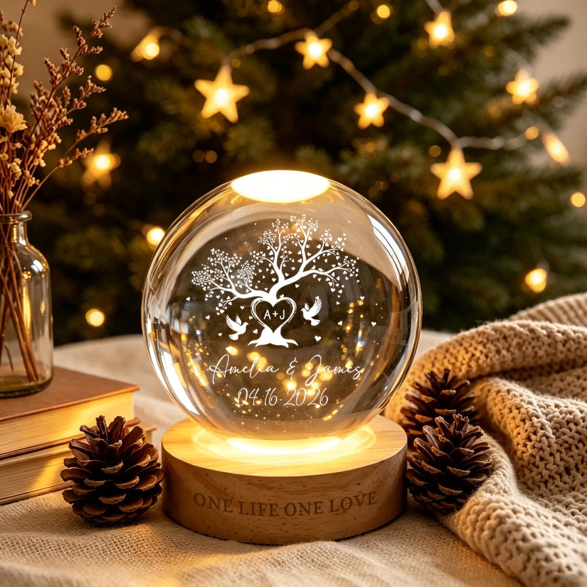 May include: A clear glass sphere lamp on a round wooden base engraved with the text ONE LIFE ONE LOVE. The sphere features an etched design of a tree with heart-shaped leaves, two birds, the initials A+J, and the text Amelia & James 04.16.2026.