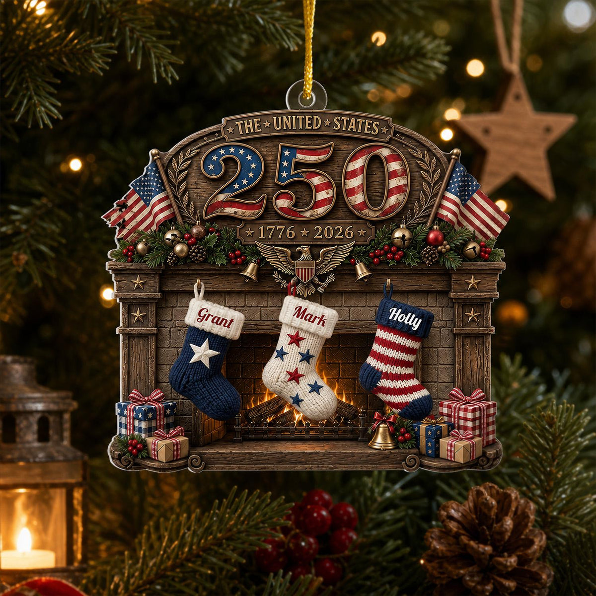 May include: A decorative Christmas ornament featuring a fireplace mantel with the text THE UNITED STATES 250 1776 2026. Three stockings hang from the mantel, labeled Grant, Mark, and Holly, alongside American flags, gifts, and a golden eagle.