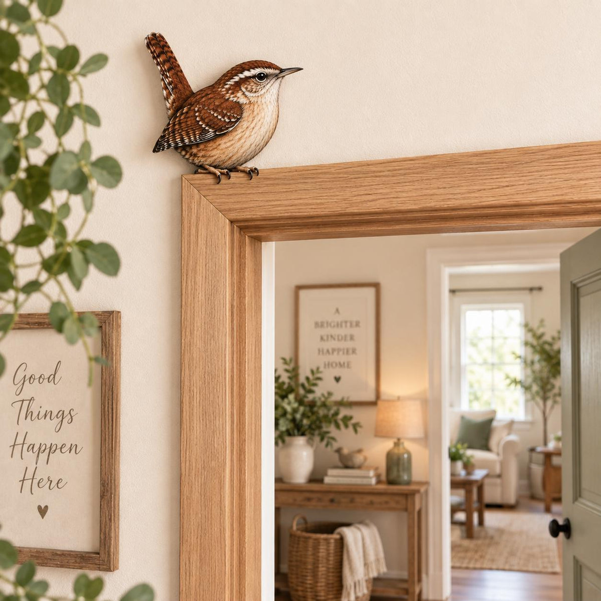 May include: A small, realistic wren figurine with brown, white, and black patterned feathers perched on the top corner of a light-colored wooden door frame. The bird has a pointed beak, a short upright tail, and detailed plumage markings.
